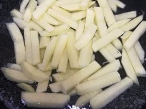 .锅中倒入冷水，放入泡过水的土豆条，开火将土豆条焯熟，用锅铲能切断土豆条的时候说明熟了，再把焯熟的土豆条过一遍冷水备用。