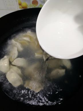 待水烧开后，倒入一饭碗冷水，水开后再倒入一饭碗冷水，直到饺子飘起来就是熟了。