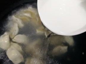 待水烧开后，倒入一饭碗冷水，水开后再倒入一饭碗冷水，直到饺子飘起来就是熟了。