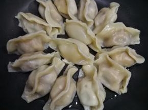 将饺子整齐摆放在平底锅内，小火把饺子底煎到微黄。