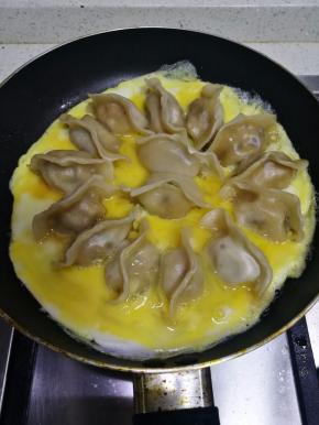 沿锅边倒入，使蛋液摊平平底锅底。