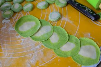 用擀面杖将小面团擀成饺子皮。