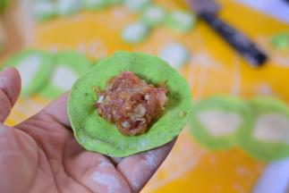 把肉馅放在饺子皮的中间。