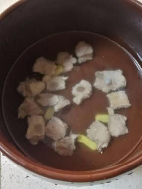 焯水的排骨放入冷水中，放入几片生姜