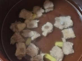 焯水的排骨放入冷水中，放入几片生姜