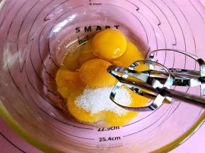 将鸡蛋打入蛋黄中，再加入三分之一的白糖，用电动打蛋器打发