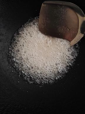 6、另起锅，加入清水30克，加入白糖，中小火熬制。边熬边用锅铲不停的搅拌。