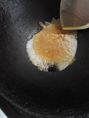 7、糖慢慢变黄色，这时火可以关小点，继续搅拌。