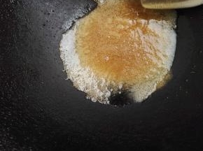 7、糖慢慢变黄色，这时火可以关小点，继续搅拌。