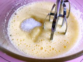 打发至蓬松变白时加入剩下的白糖，继续打发