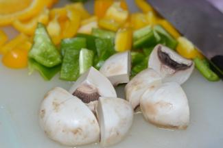 将彩椒洗净，然后去掉籽，切成小片。蘑菇洗净后切成四份。