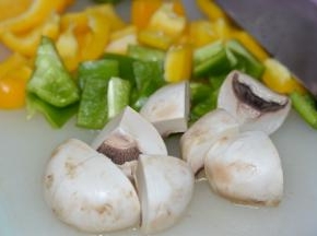 将彩椒洗净，然后去掉籽，切成小片。蘑菇洗净后切成四份。