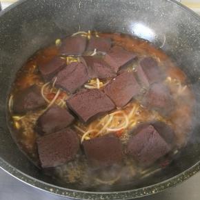 放入鸭血，加料酒和300毫升水，加盖大火烧3分钟.关火焖二分钟。