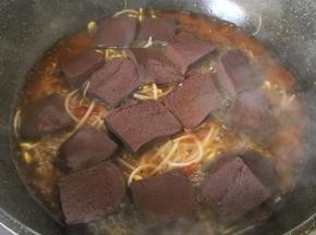 放入鸭血，加料酒和300毫升水，加盖大火烧3分钟.关火焖二分钟。