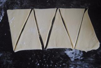 开始塑形，将面片稍压扁，用擀面杖擀成长方形，力度要轻柔，擀成大约是0.3CM厚度的面片，大概长度是50CM，宽度是20CM.再用锋利的刀把面片长边10厘米长度做一个标志，再分成高度为20cm的等边三角形