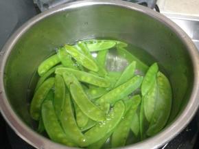 锅内加盐、几滴食用油烧开，倒入荷兰豆焯水至断生后捞出过冷水备用