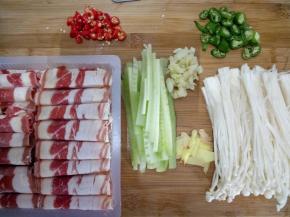 金针菇切去上头一部分并把它掰开。黄瓜去皮切细长条。姜切片，蒜拍碎切末。双椒切小段。