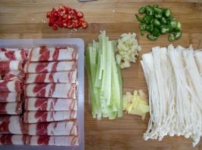 金针菇切去上头一部分并把它掰开。黄瓜去皮切细长条。姜切片，蒜拍碎切末。双椒切小段。