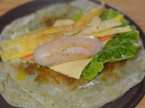 再放上洗净的生菜、芝士片、胡萝卜和鸡蛋丝，最后是香肠。