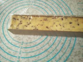 把保护膜铺在饼干模具上，把蔓越莓面团放进模具中，整理贴合，放进冰箱冷冻1小时冻硬