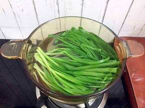 锅中烧开水后放入韭菜焯烫