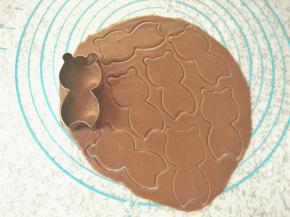 拿出面团，取其中一份擀成3mm的薄饼状，用模具刻出小浣熊身体模型