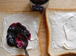 奶酪上涂抹一层蓝莓果酱，果酱涂抹在一片吐司上即可