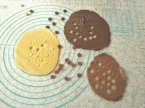 剩余的面团再擀成圆饼状，用小圈模具刻出小浣熊的小手