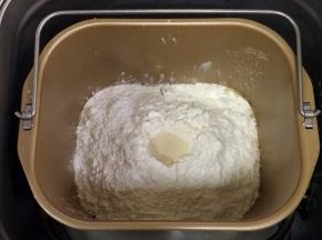 除黄油以外的面包材料都放入面包机内（先液体后粉类的顺序），在面粉中间挖个洞，把酵母粉倒入，启动和面程序。