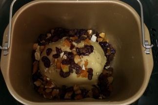 继续约揉至20分钟，面团表面光滑且具有延展性，加入酒渍葡萄干和蔓越莓以及切碎的杏仁和杏干全部揉进面团里。