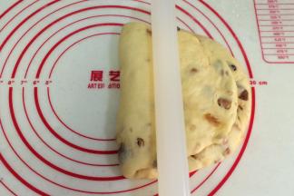 把擀平部分折叠到上方，用擀面杖压下。