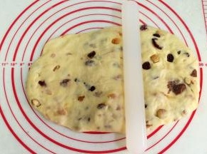 取一份松弛好的面团，把面团擀成椭圆面片，在1/3处擀平，在2/3处中间用擀面杖压出凹槽。