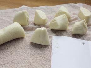 6. 在案上铺一块湿布，将面团揉搓成长条，分割成若干等份。