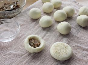 8. 取一份，用大拇指按一小窝，放点馅料，包起来；一面沾上芝麻，然后按扁。
注：馅料根据自己的喜爱自由选择。