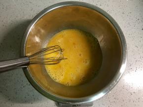 在不锈钢盆里打入两个鸡蛋搅匀。