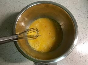 在不锈钢盆里打入两个鸡蛋搅匀。