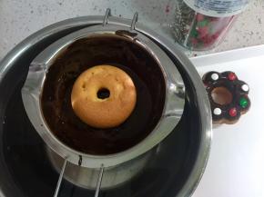 把纯圆的甜甜圈的正面朝下，蘸上巧克力酱。