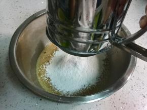 往蛋液中筛入100克低筋面粉和3克泡打粉。