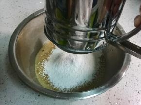 往蛋液中筛入100克低筋面粉和3克泡打粉。
