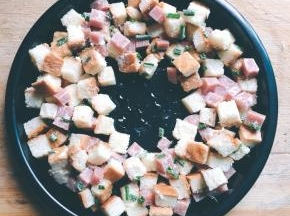 8寸不沾披萨烤盘底部抹油，可以是色拉油也可以是黄油，将搅拌均匀的食材用勺子铺在烤盘里，中间留一点空间用来打蛋