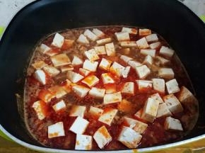 下豆腐，用锅铲轻轻的将它推开，中小火煮个五六分钟让其入味。