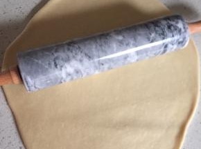 取出面团，用擀面杖排气。