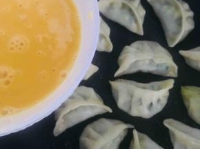 待锅中水分收干时，延锅边慢慢倒入蛋液
