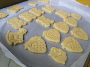 把边角料移除后团成面团，再次重复擀开印模操作，直至整个面团都印成可爱的形状在油纸上