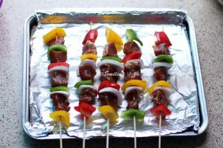 将彩椒、洋葱块和腌制好的肉块串在竹签上，基本是一块彩椒一块肉，洋葱可以少串一些，然后两面刷油，烤箱预热，200度，肉串放烤网上于烤箱中层烤制，烤盘上铺锡纸放在烤箱下层接油，烤串两面各烤制12分钟，就是先烤12分钟，再翻面烤12分钟，总共24分钟哦，具体情况看烤箱温度和肉块大小