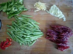 豆角洗净切斜刀，蒜拍碎切末，生姜切丝 ，彩椒切丝，腊肠切片，小米椒切小段。