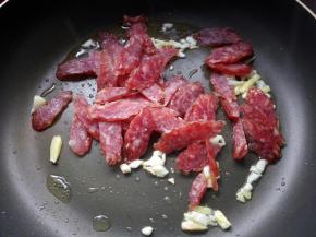 放入腊肠翻炒均匀。