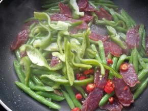 放入彩椒和小米椒翻炒，加少量水。