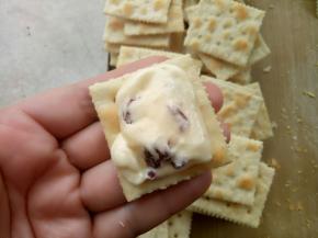 用刮刀挖一点粘在两片苏打饼干中间。就OK了。