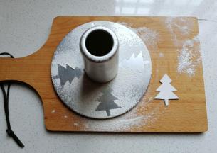 先做准备工作：用硬纸剪出圣诞树模型，然后摆在中空模具底坐上筛上面粉，移开后就得到圣诞树轮廓了，然后轻轻移置旁边备用；